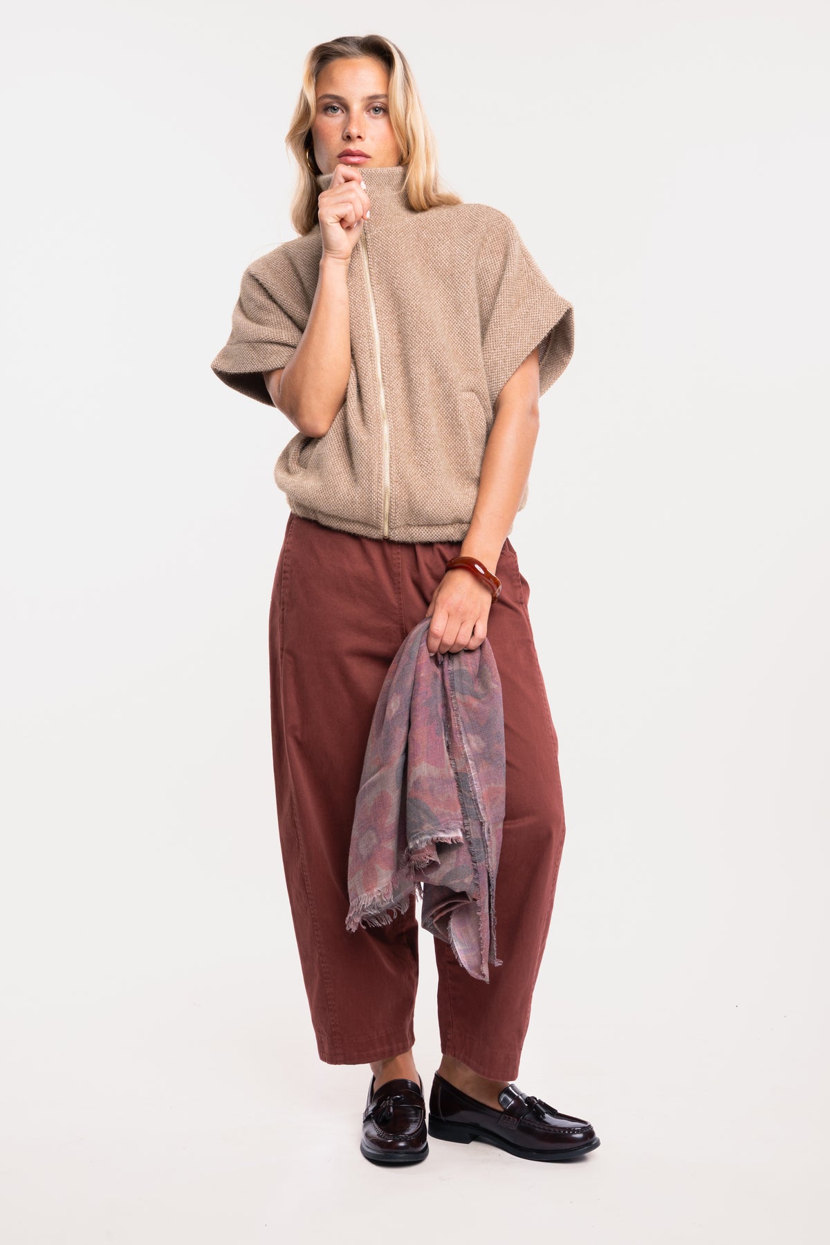 Veste zippée oversize écru avec un pantalon barrel acajou, paire de mocassins et un foulard fleuri prune