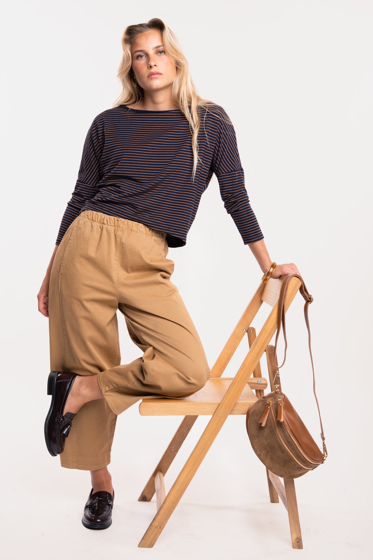 Un top à col bateau rayé marine et camel, un pantalon barrel camel et une paire de mocassins