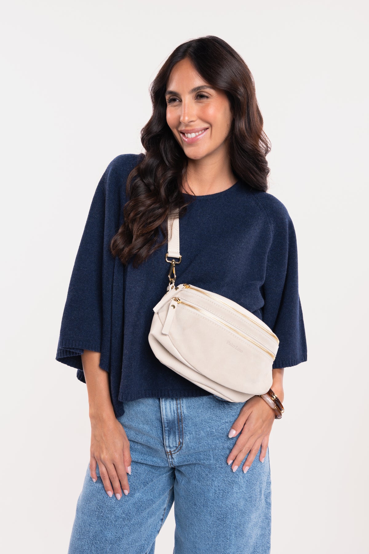 Sac banane en cuir écru avec un pull oversize marine et un jean barrel délavé clair