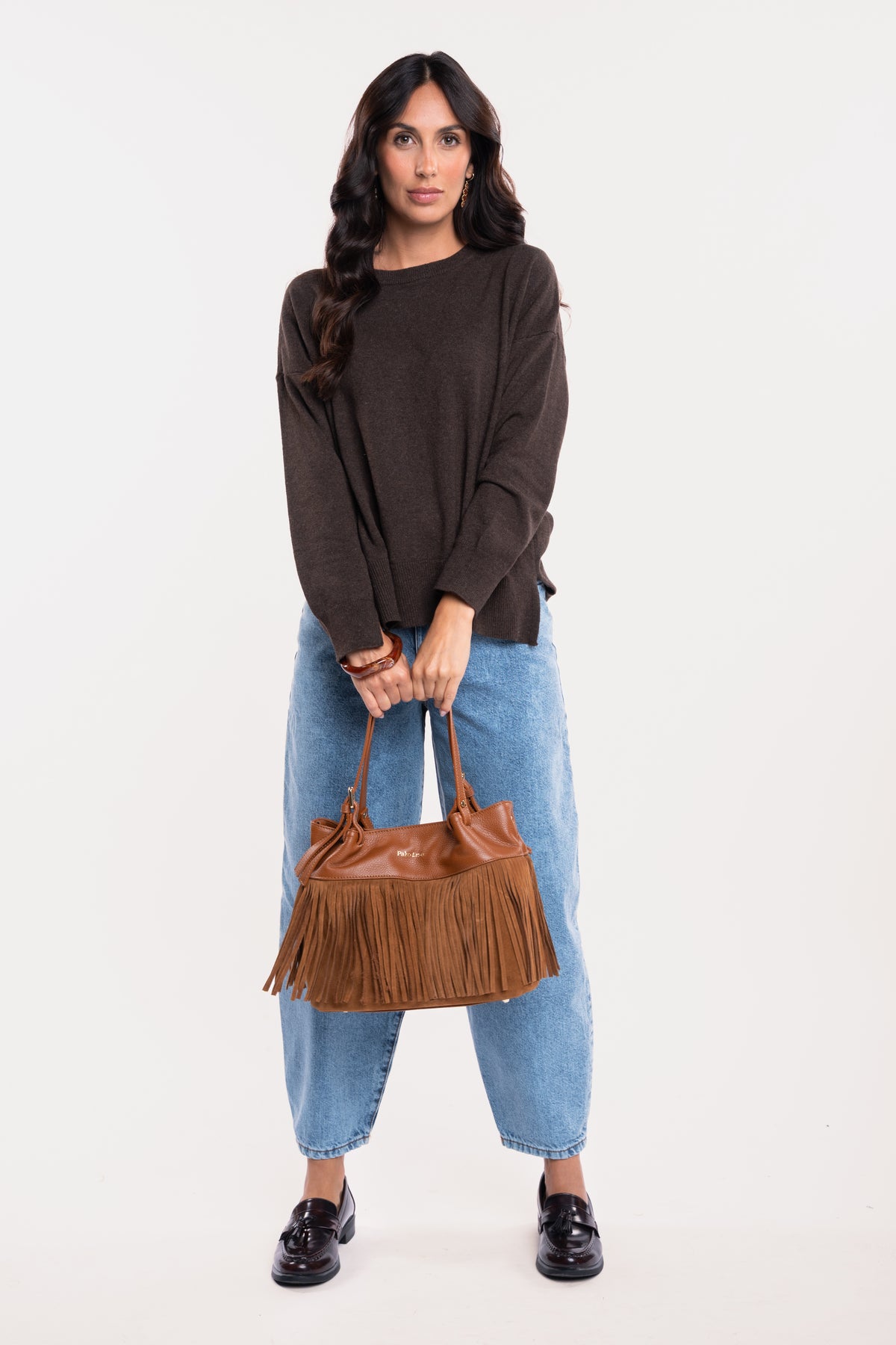 Sac en cuir à franges camel avec un pull oversize marron, un jean barrel délavé clair et une paire de mocassins