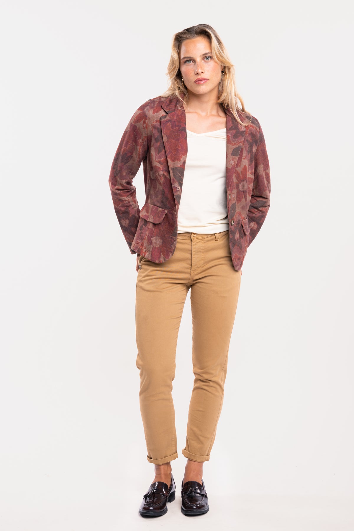 Un blazer imprimé prune, un T-shirt à col V écru, un pantalon chino 7/8ᵉ camel et une paire de mocassins 