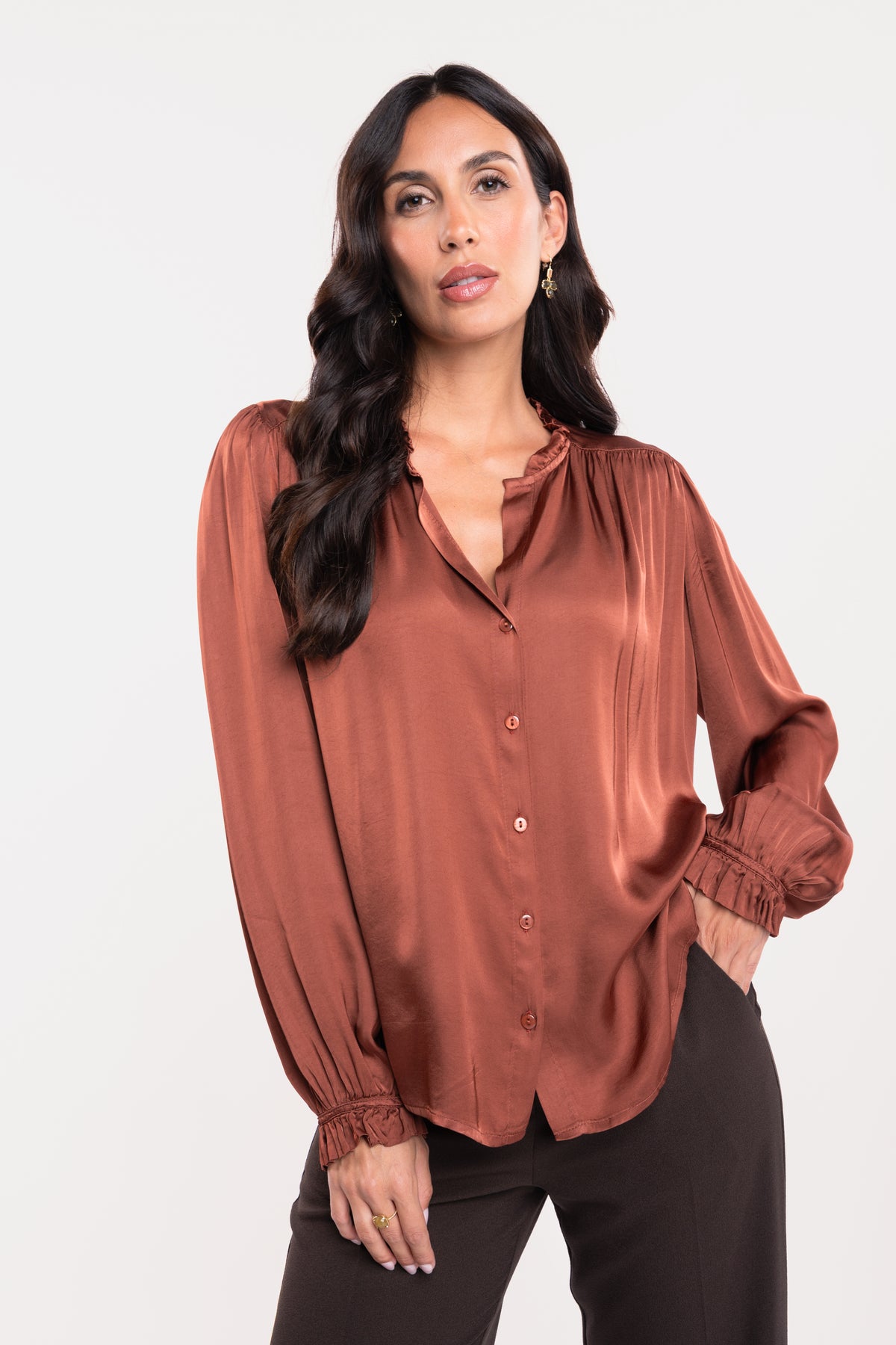 Une chemise en satin acajou et un pantalon de tailleur marron 