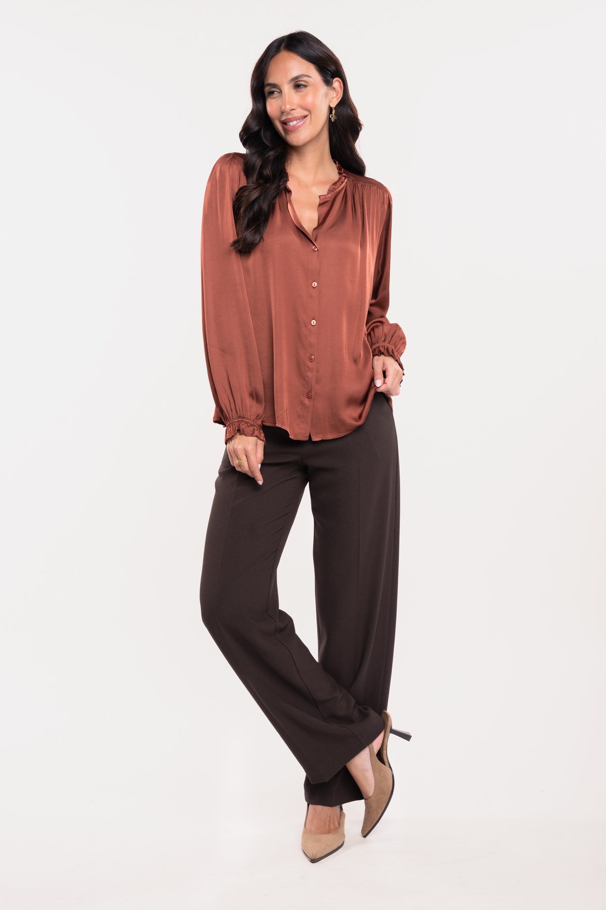 Une chemise en satin acajou, un pantalon de tailleur marron et une paire de talons beiges