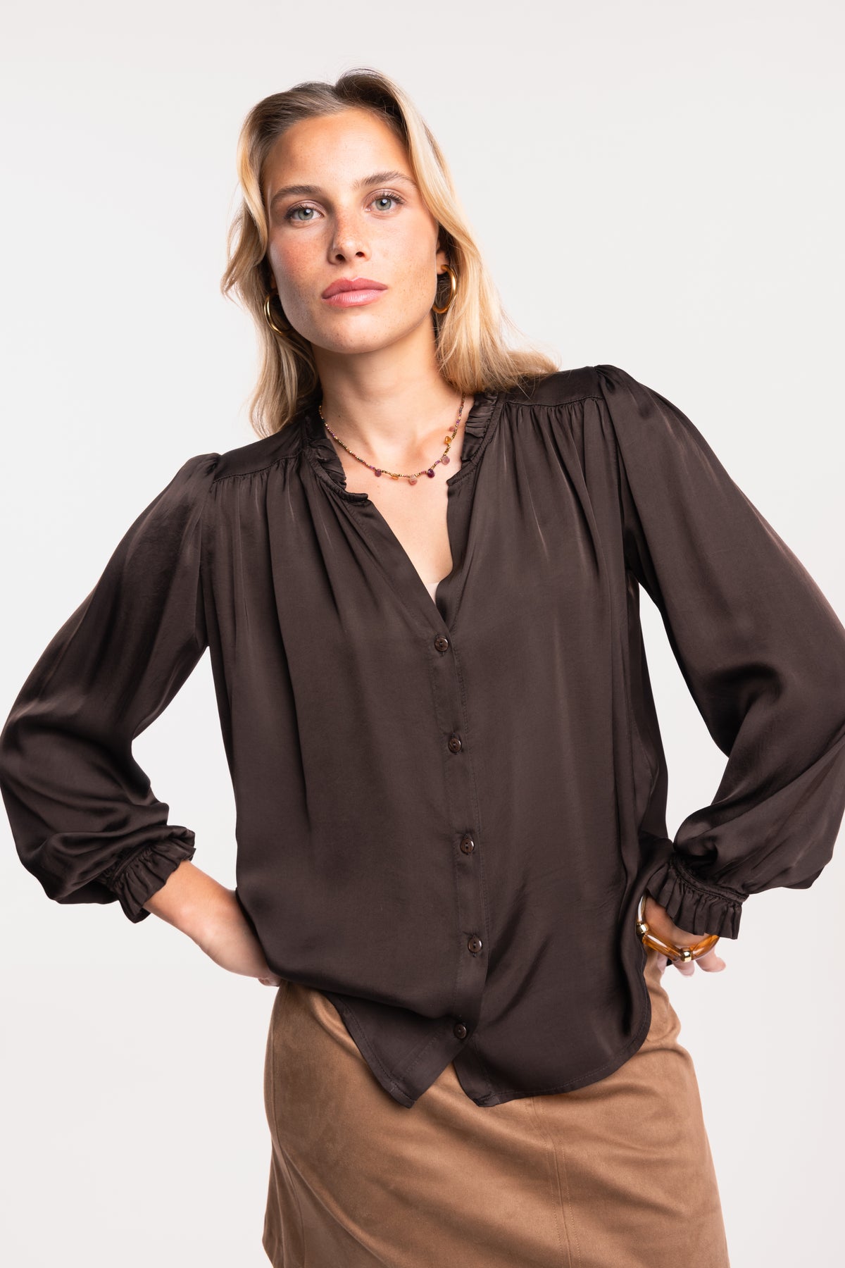Une chemise en satin marron et une jupe courte en suédine camel