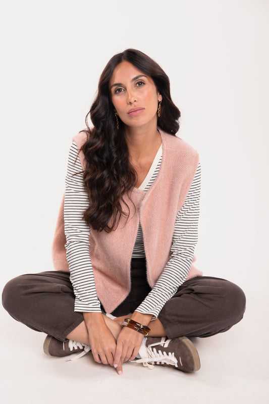 Gilet sans manches vieux rose avec un t-shirt col V rayé écru et marron, un pantalon barrel marron et une paire de baskets marron