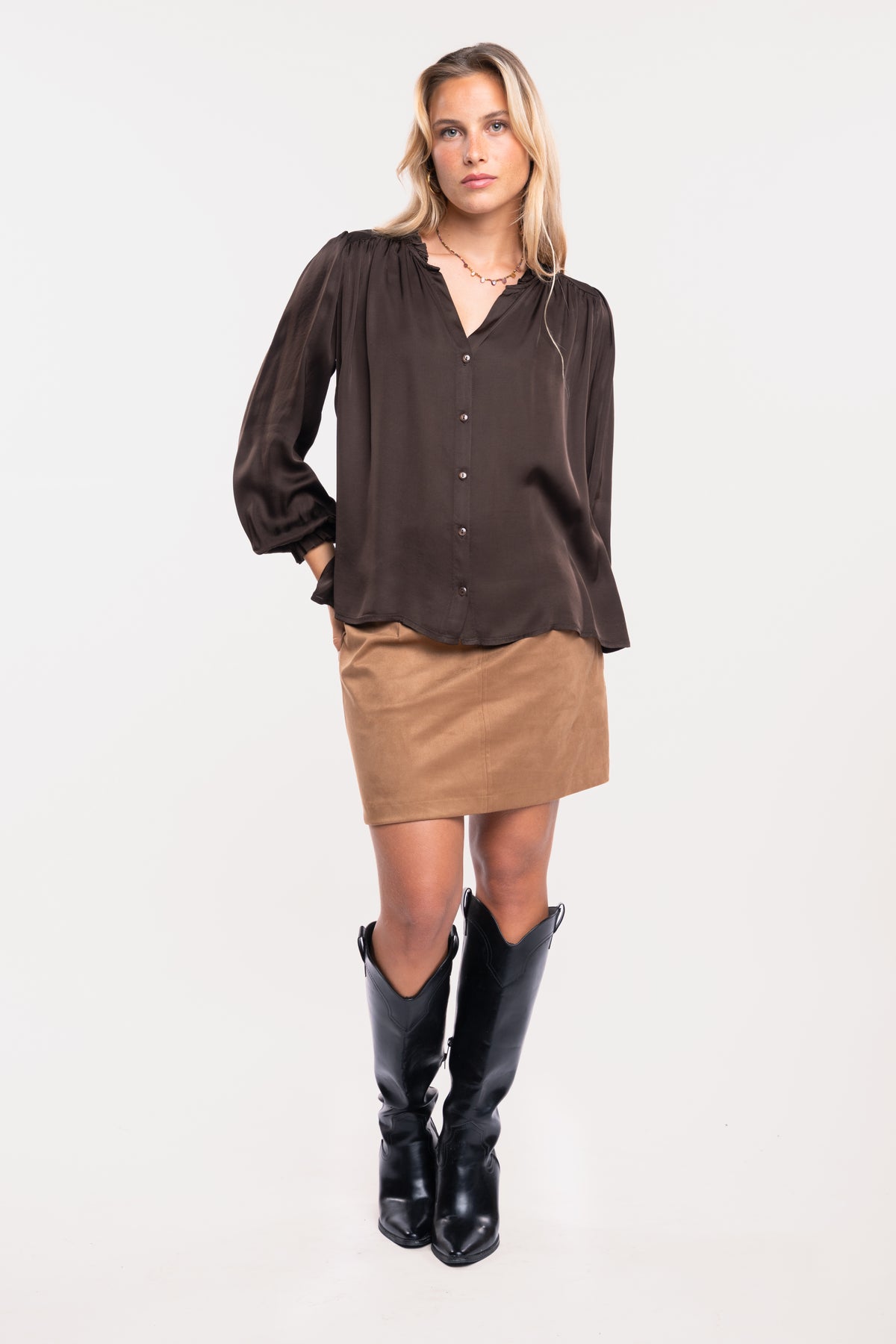 Chemise satinée marron avec une jupe en suédine camel et une paire de bottes noires 
