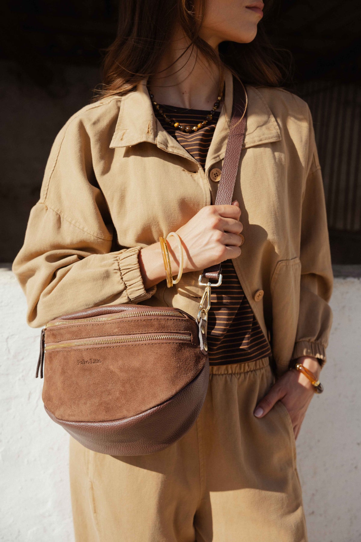 Veste ample camel avec t-shirt col bateau rayé marron, sac banane en cuir marron et pantalon barrel camel 