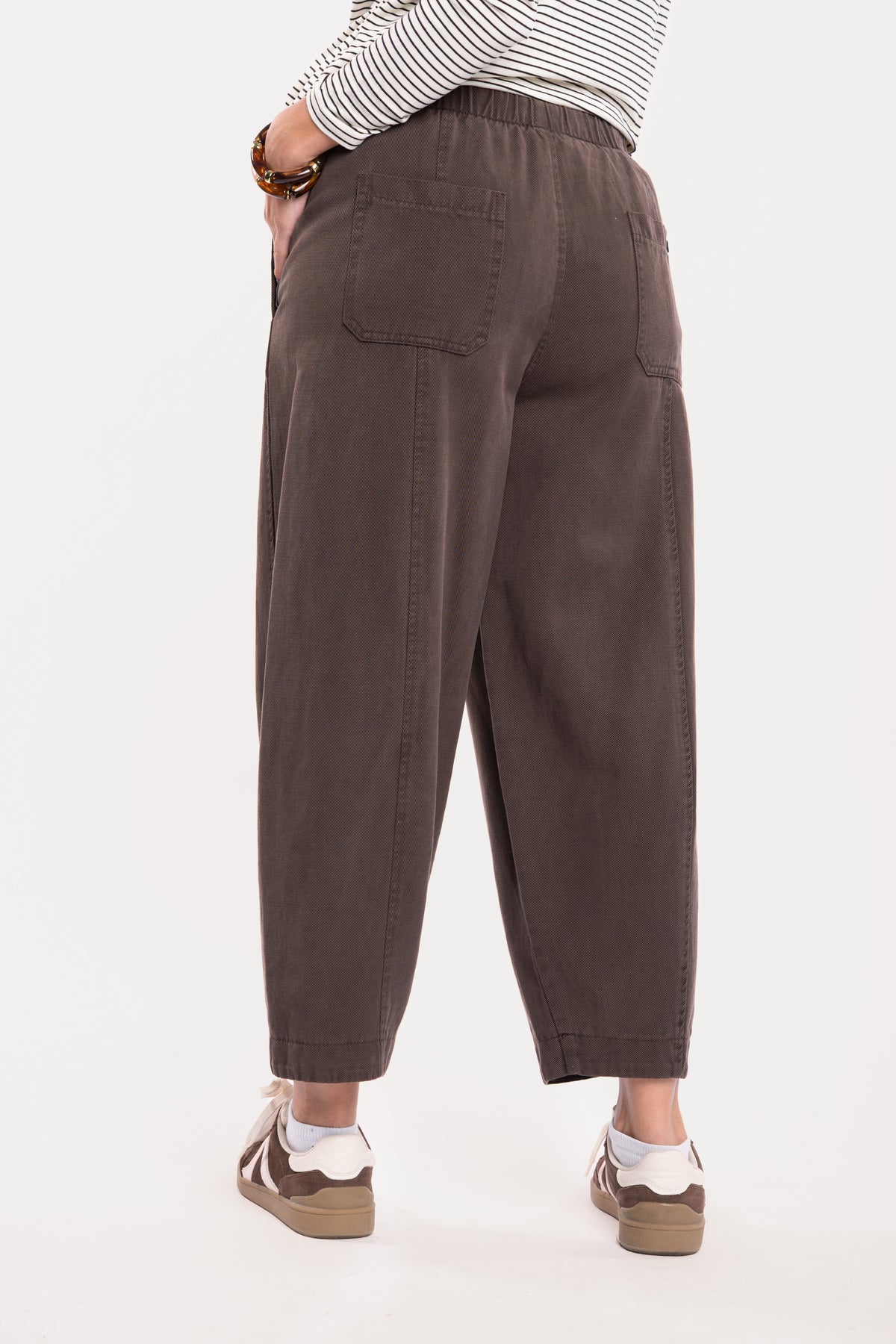 Pantalon ballon marron et une paire de baskets marron de dos