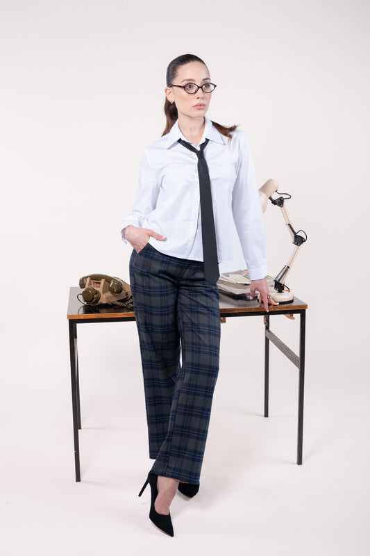 Chemise blanche avec cravate noir, pantalon à carreaux évasé long élastiqué dos gris marine et escarpin 