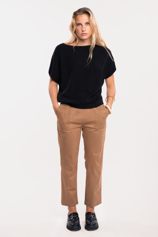 Pull sans manches noir avec un pantalon cintré camel et des mocassins noirs 