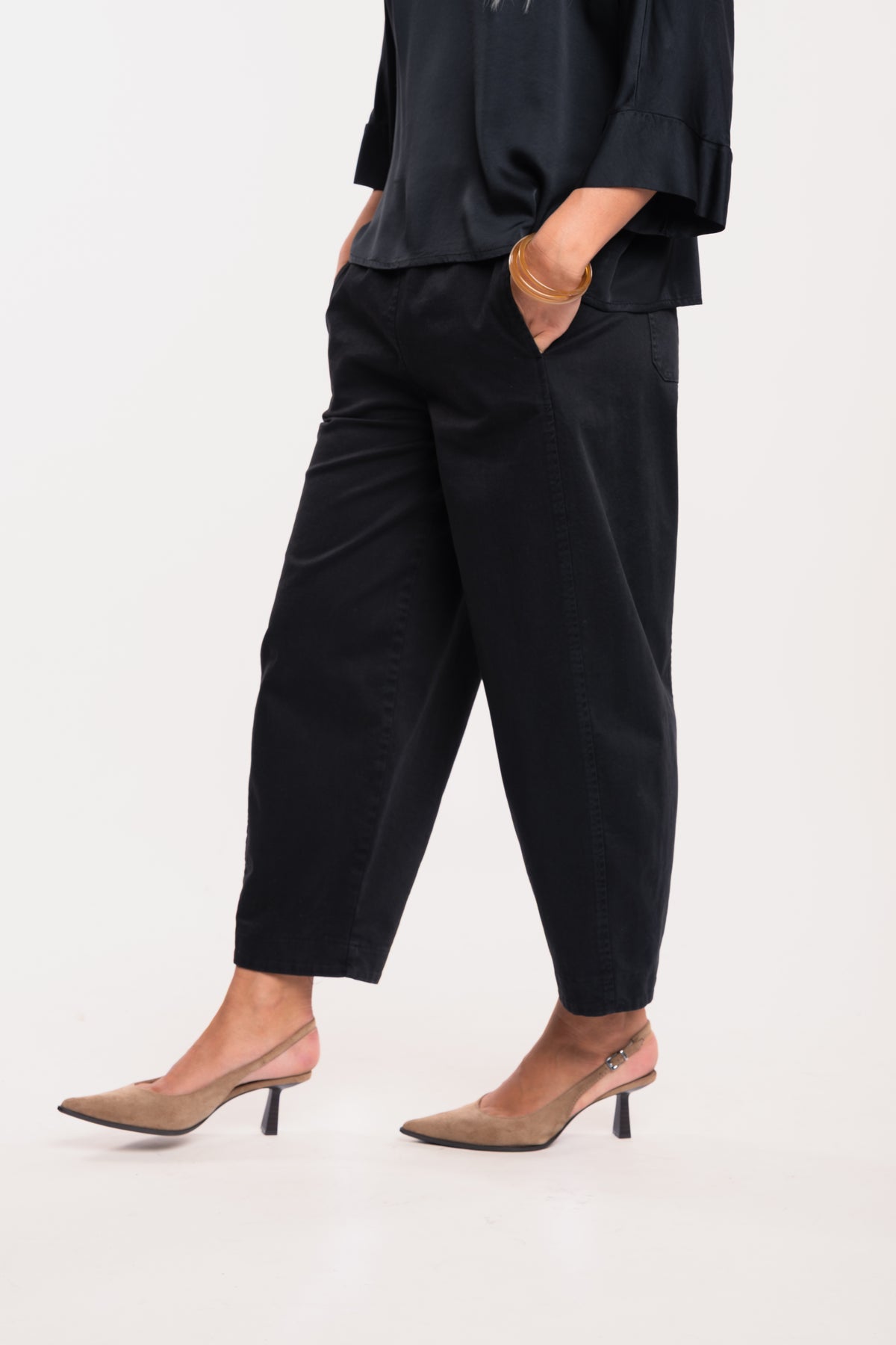 Blouse satinée noir avec pantalon barrel noir et paire de talons beiges 