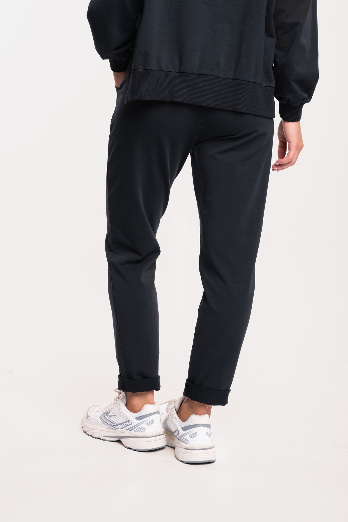Pantalon de jogging noir et basket blanche de dos