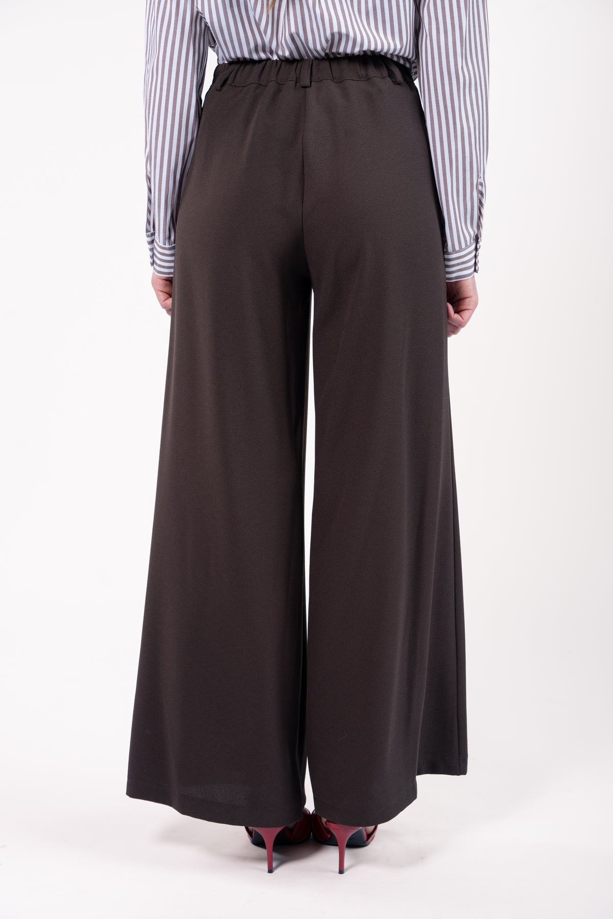 Chemise courte manches longues rayées choco avec pantalon maxi évasé marron avec escarpin rouge de dos