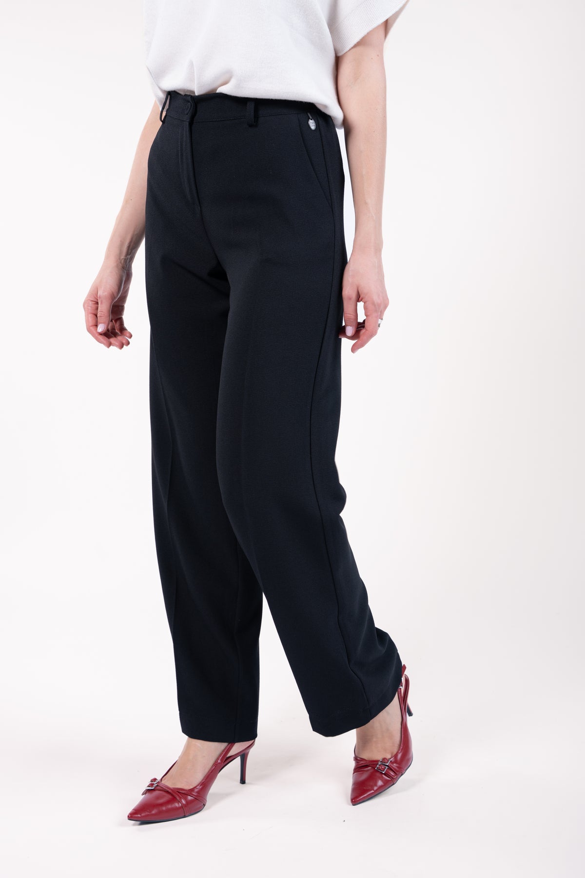 Pull col rond ample sans manches naturel avec pantalon évasé long noir et escarpin rouge