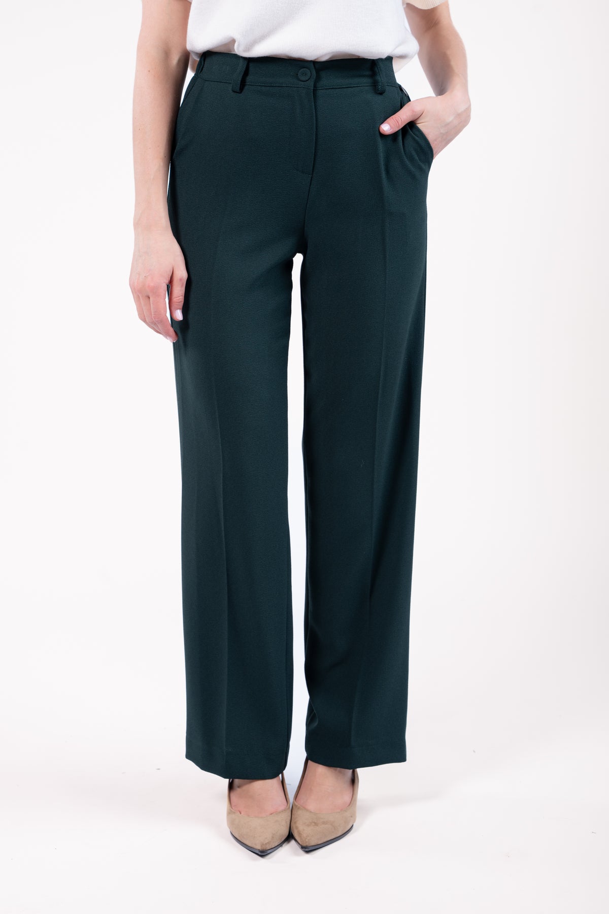 Pull col rond ample sans manches naturel avec pantalon évasé long vert et talon beige