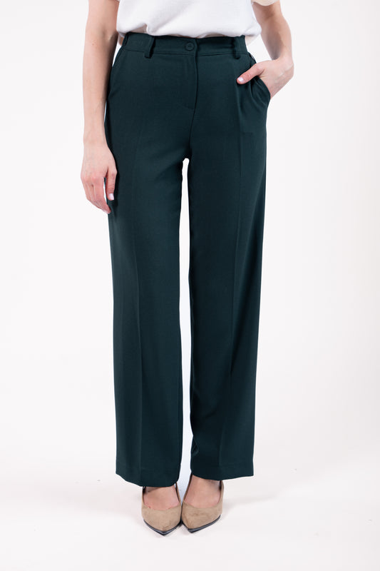 Pull col rond ample sans manches naturel avec pantalon évasé long vert et talon beige