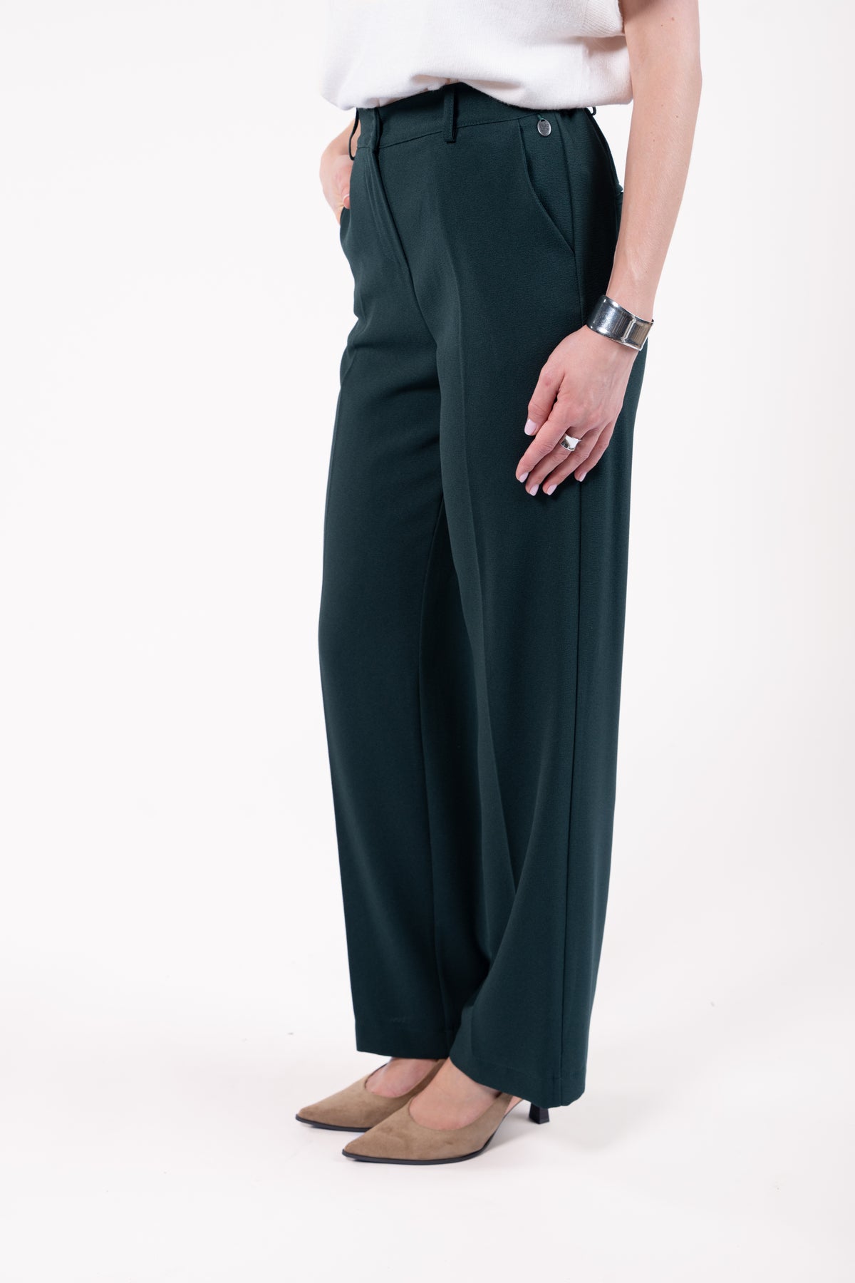 Pull col rond ample sans manches naturel avec pantalon évasé long vert et talon beige