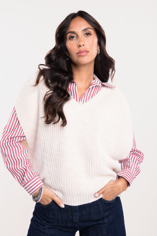 Un pull ample à col V écru, une chemise à rayures rouges et un pantalon jean brut