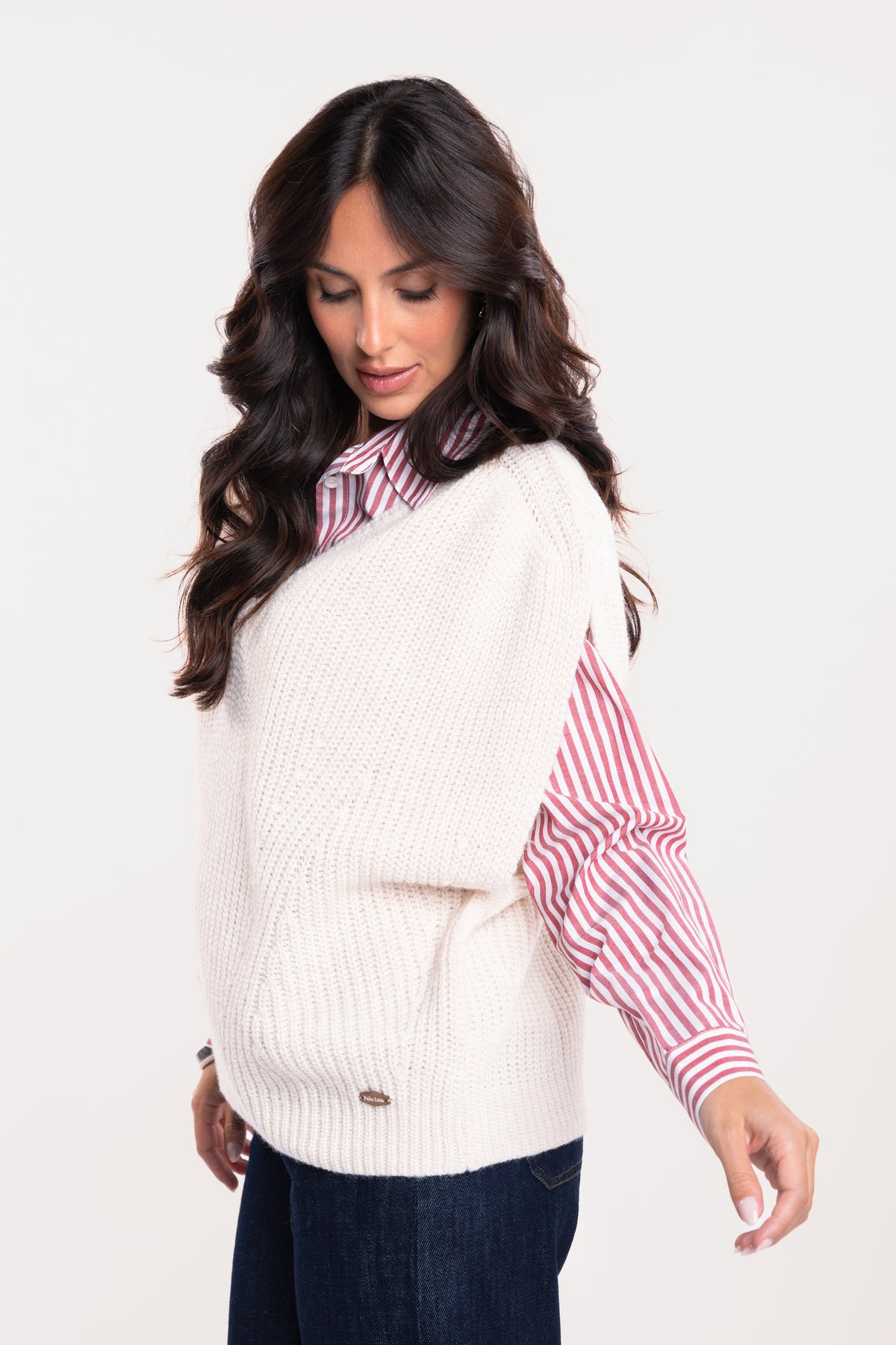 Un pull ample à col V écru, une chemise à rayures rouges