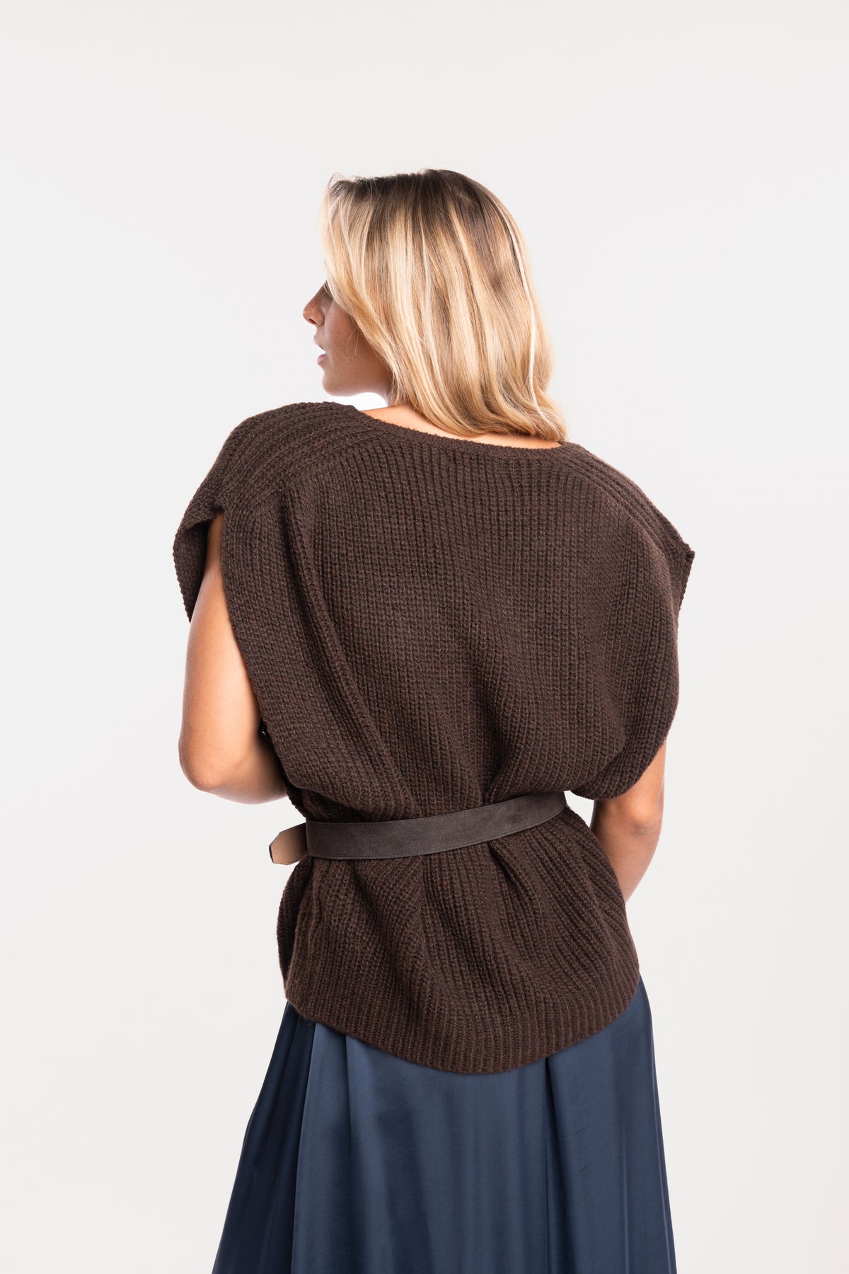 Un pull ample à col V marron, une ceinture en daim marron de dos