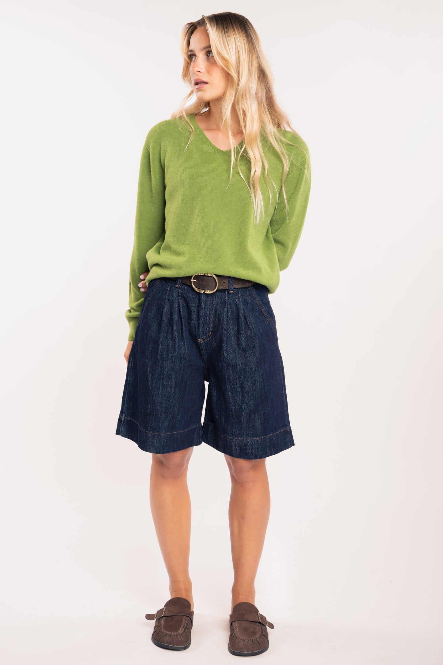 Pull ample femme vert, ceinture daim marron et bermuda long denim 