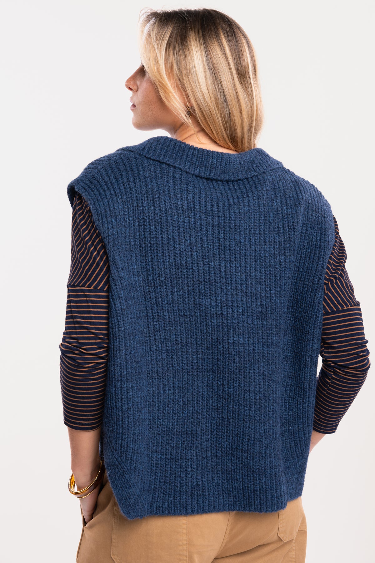Un pull col polo bleu, un top à col bateau rayé marine et tabac, un pantalon barrel camel de dos