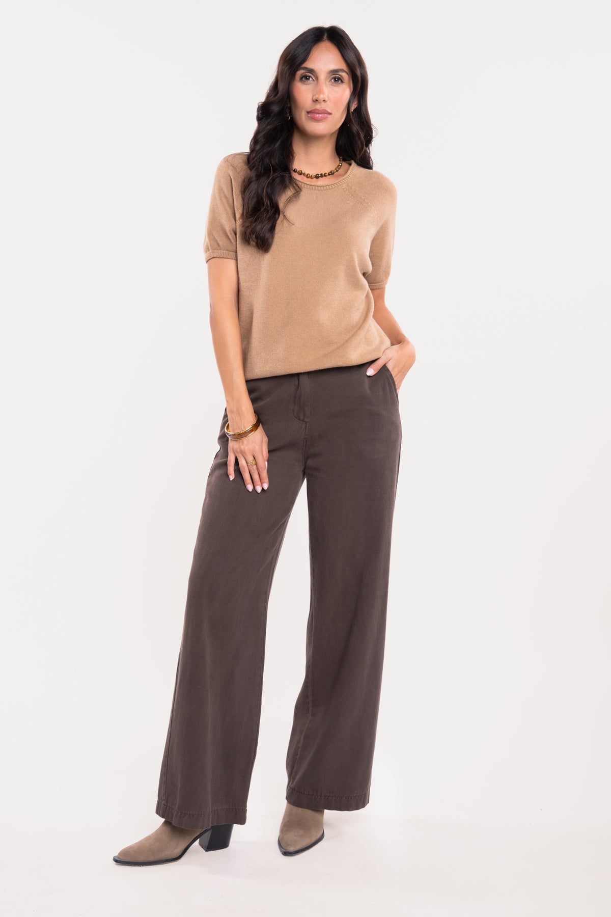 Pull manches courtes camel avec un pantalon évasé marron et une paire de talons beiges