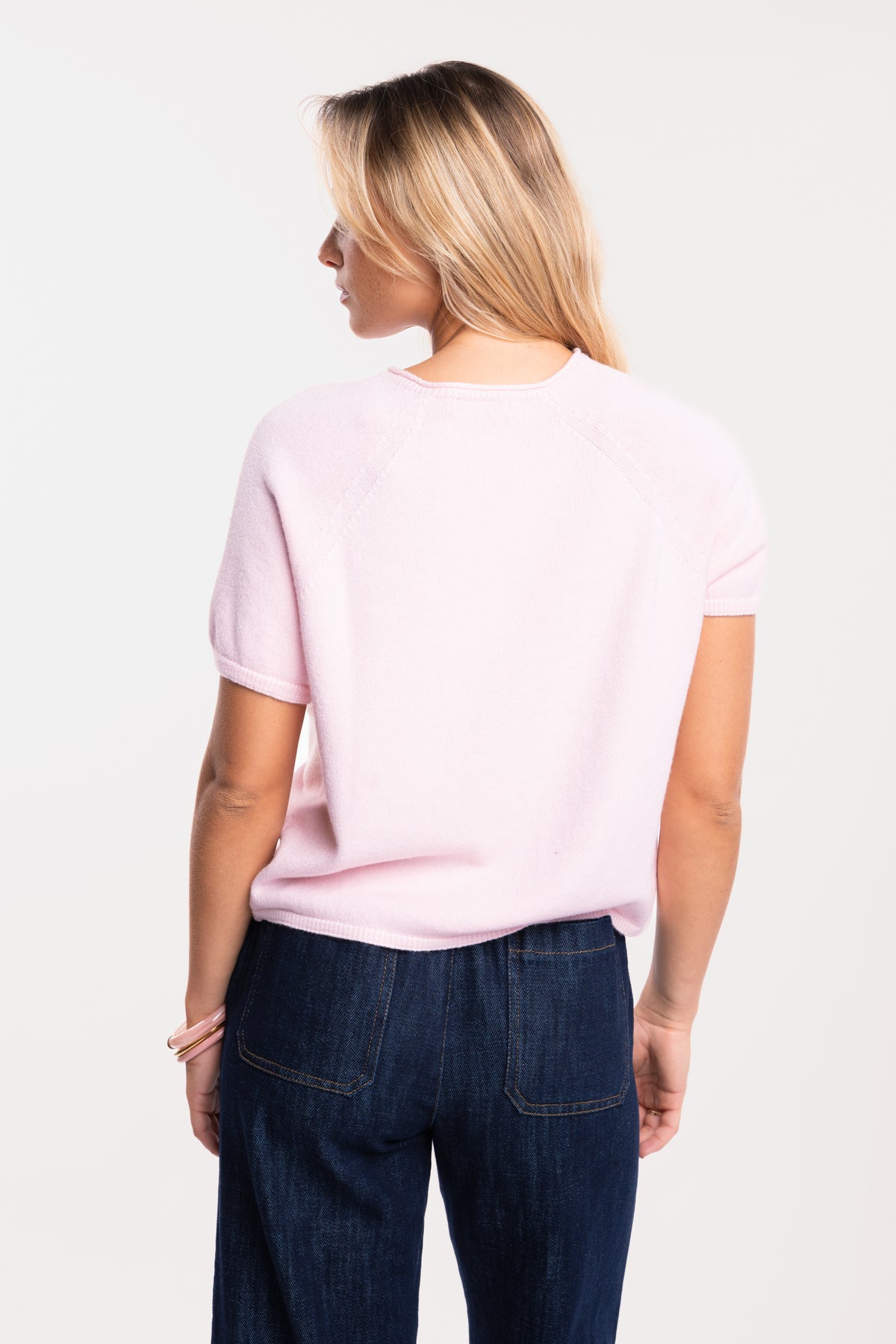 Pull manches courtes rose avec un jean brut 7/8ème de dos