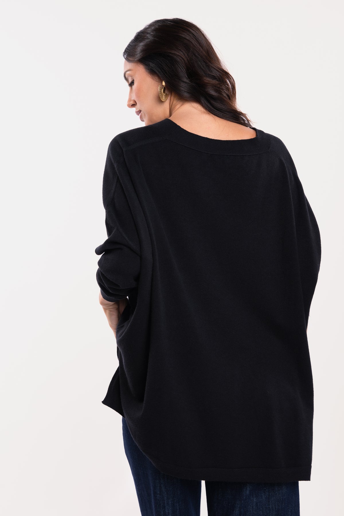Pull oversize noir avec pantalon en jean brut de dos