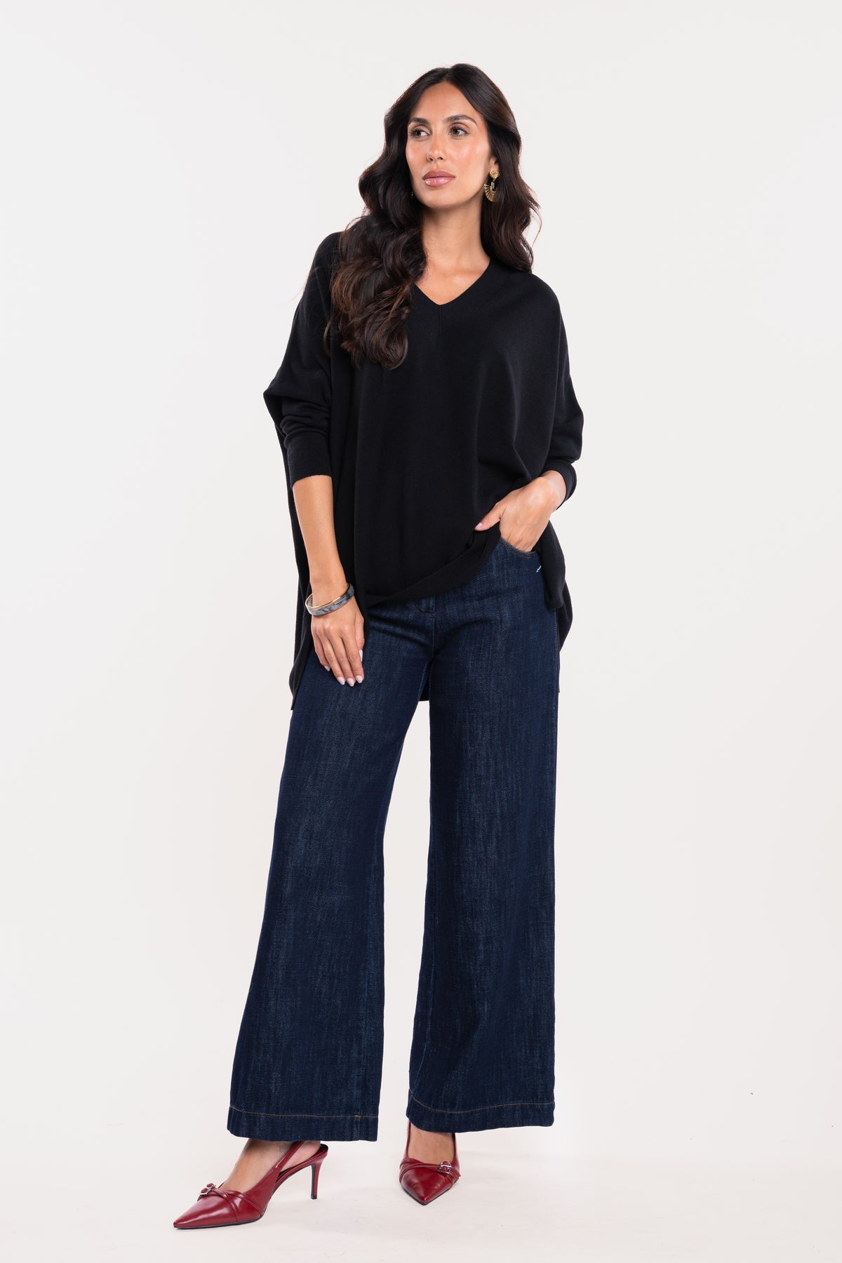 Pull oversize noir avec pantalon en jean brut et paire de talons rouges