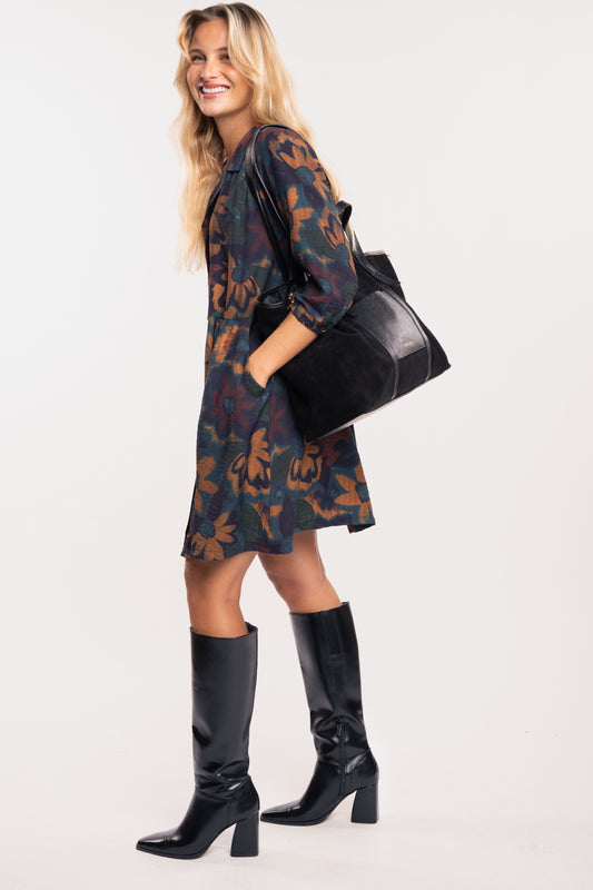 Sac cabas en cuir noir avec une robe à fleurs marine et paire de bottes noires