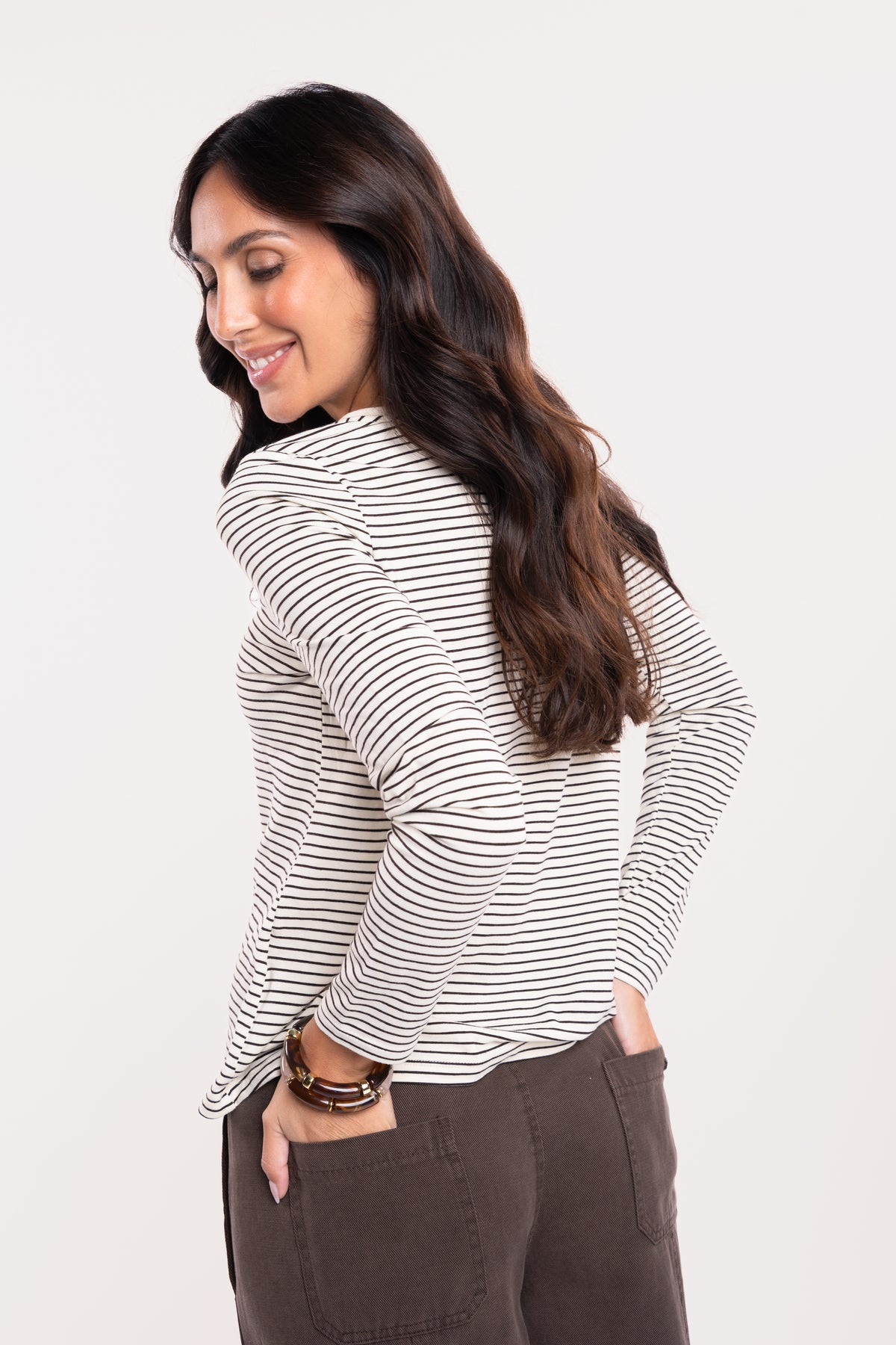 Un T-shirt rayé écru et marron, un pantalon barrel marron de dos
