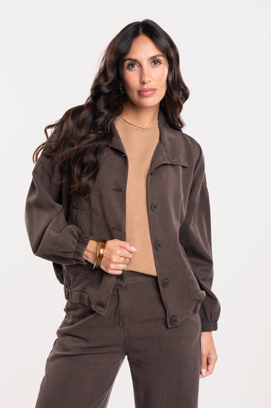 Une veste ample marron, un pull à manches courtes camel, un pantalon évasé marron