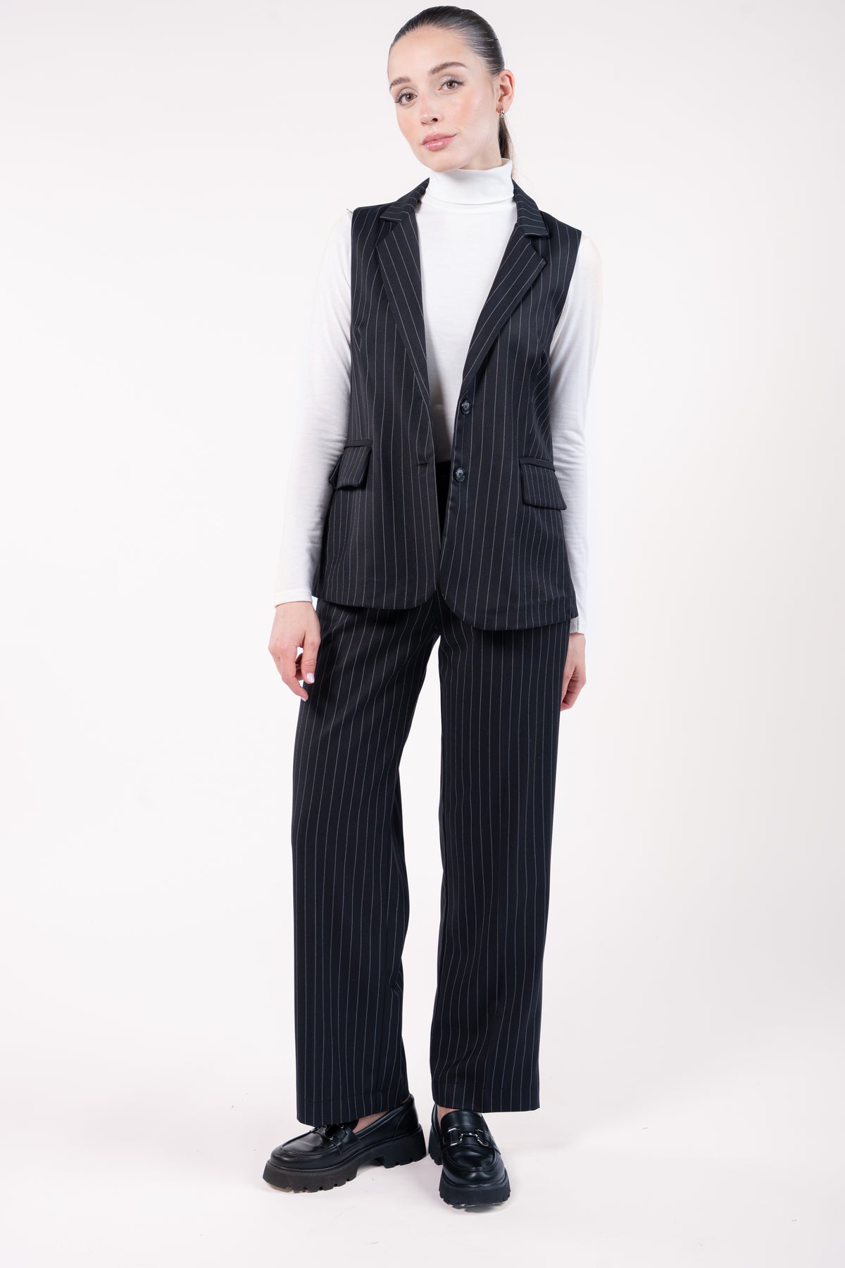 Veste sans manches et pantalon évasé long élastiqué dos rayé noir et t-shirt craie avec mocassin noir