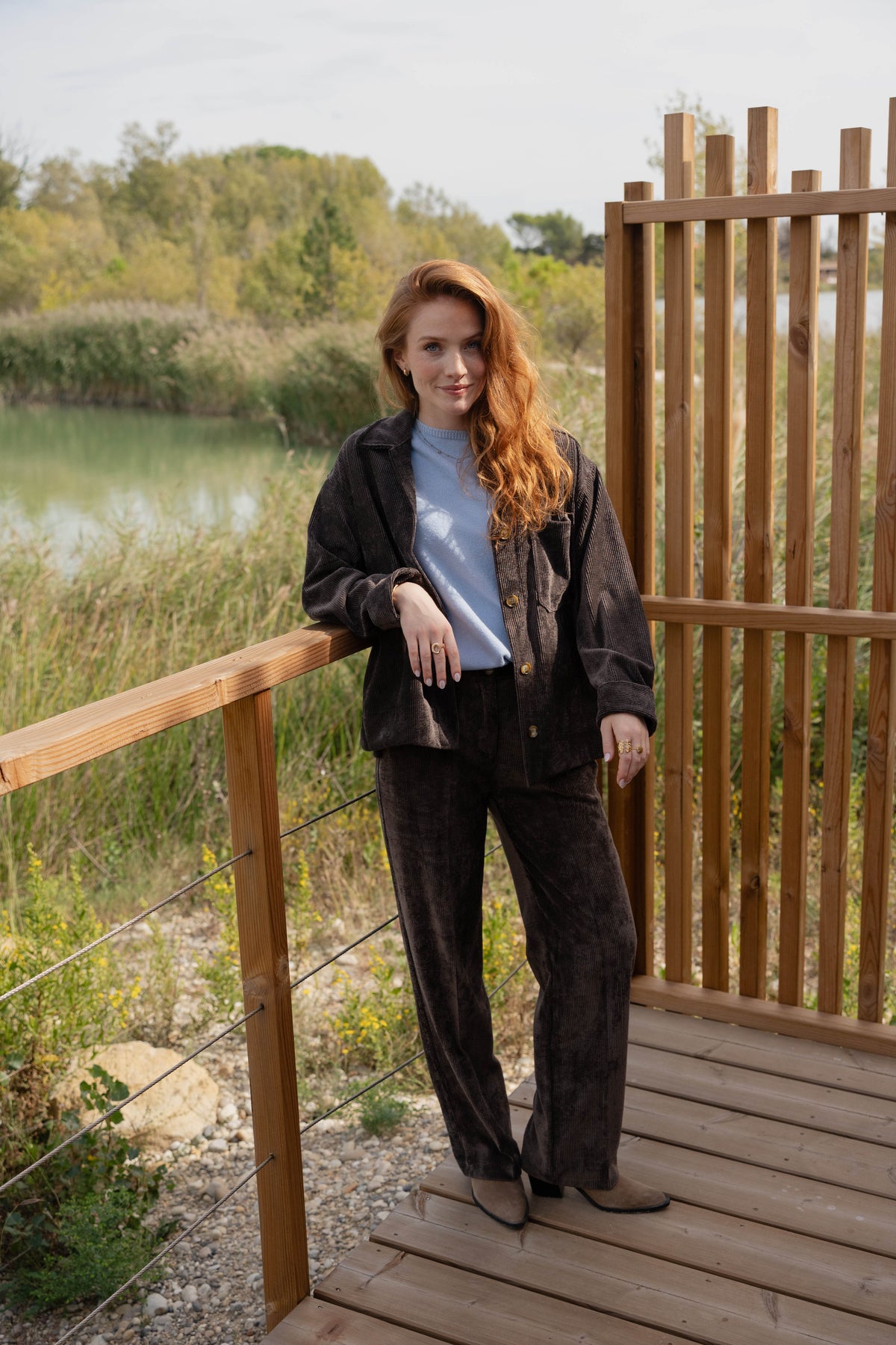Veste oversize marron, pull bleu ciel, pantalon long velours marron et paire de bottes beige